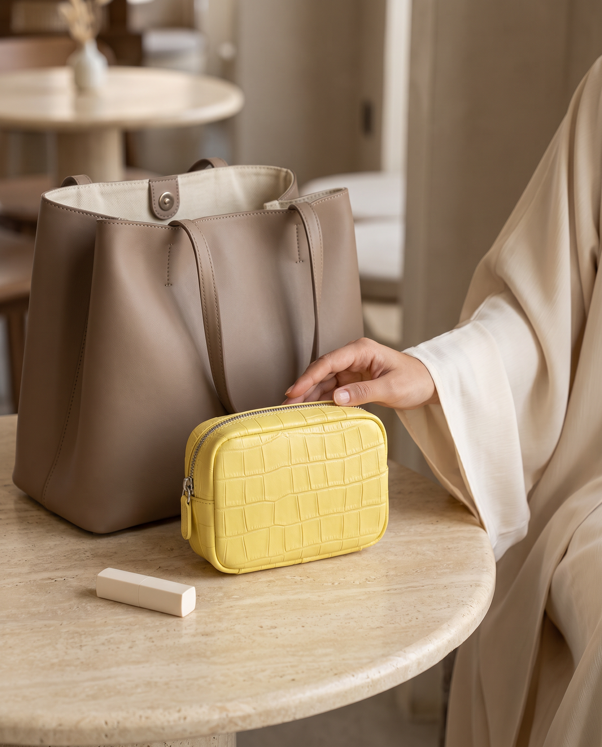 Lip Essential in Yellow — beside a handbag